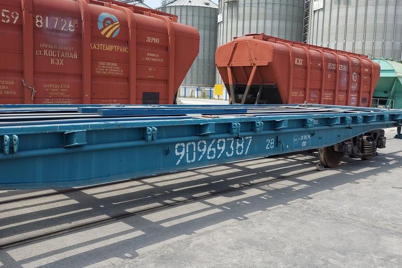 Hopper wagons beside silos