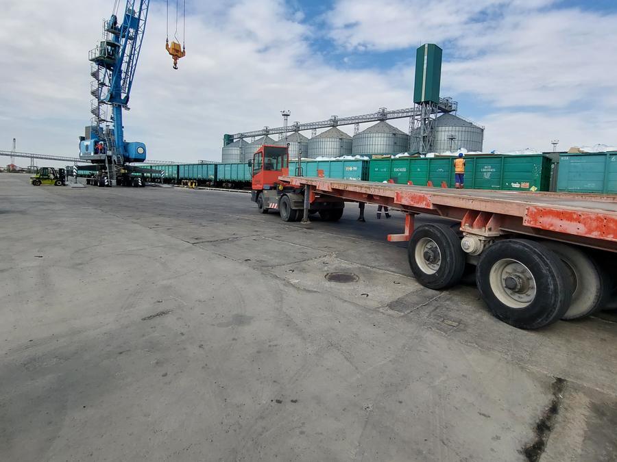 Trucks on the quay beside port cranes